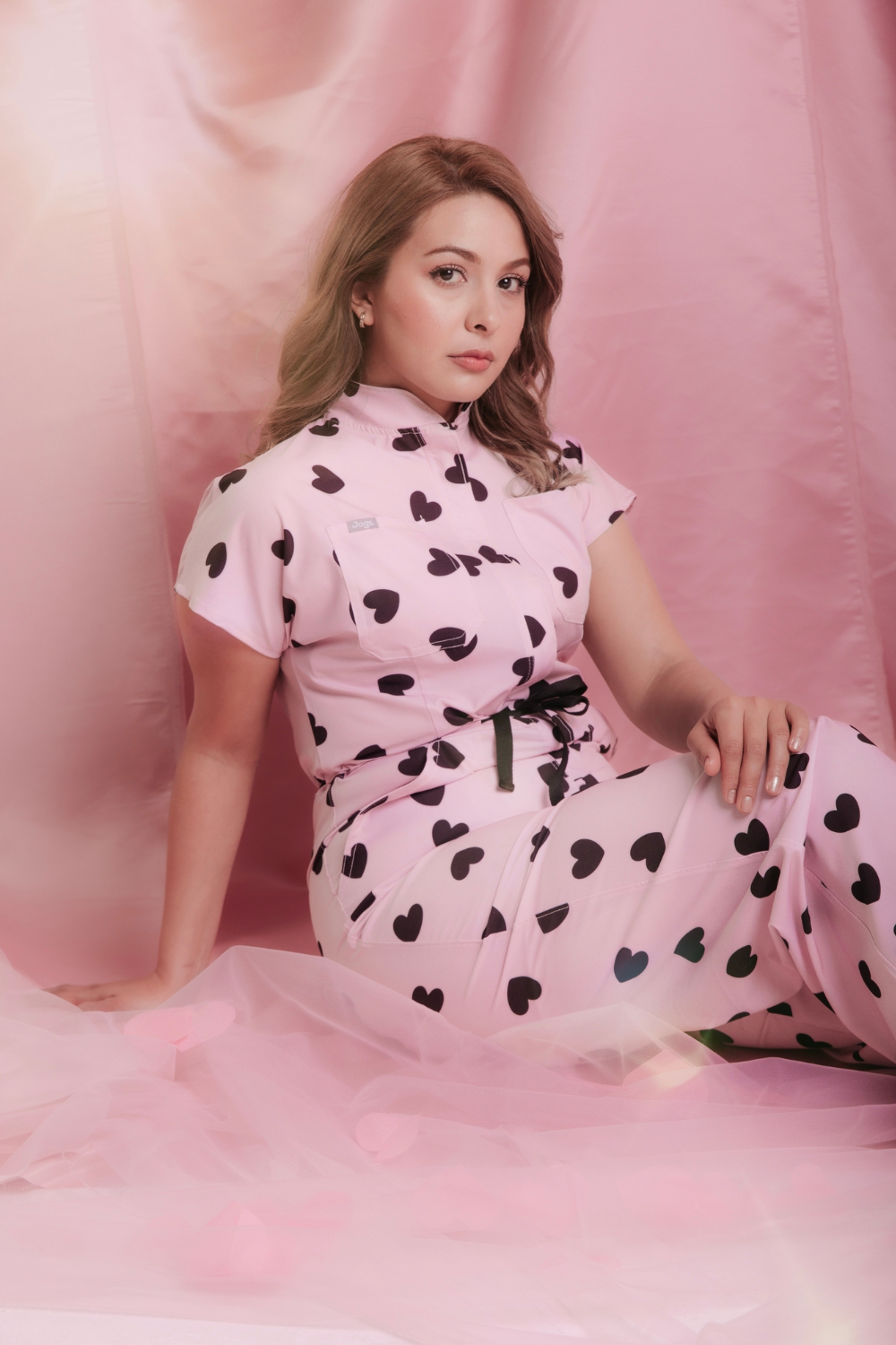 Estampado exclusivo Sweetheart de Jogs Scrubs — corazones vino sobre rosa pastel en tela antifluidos elástica